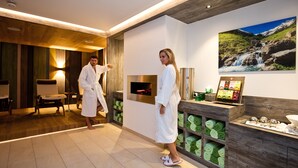 Um spa com detalhes em madeira, lareira e uma grande pintura de uma cachoeira na parede.