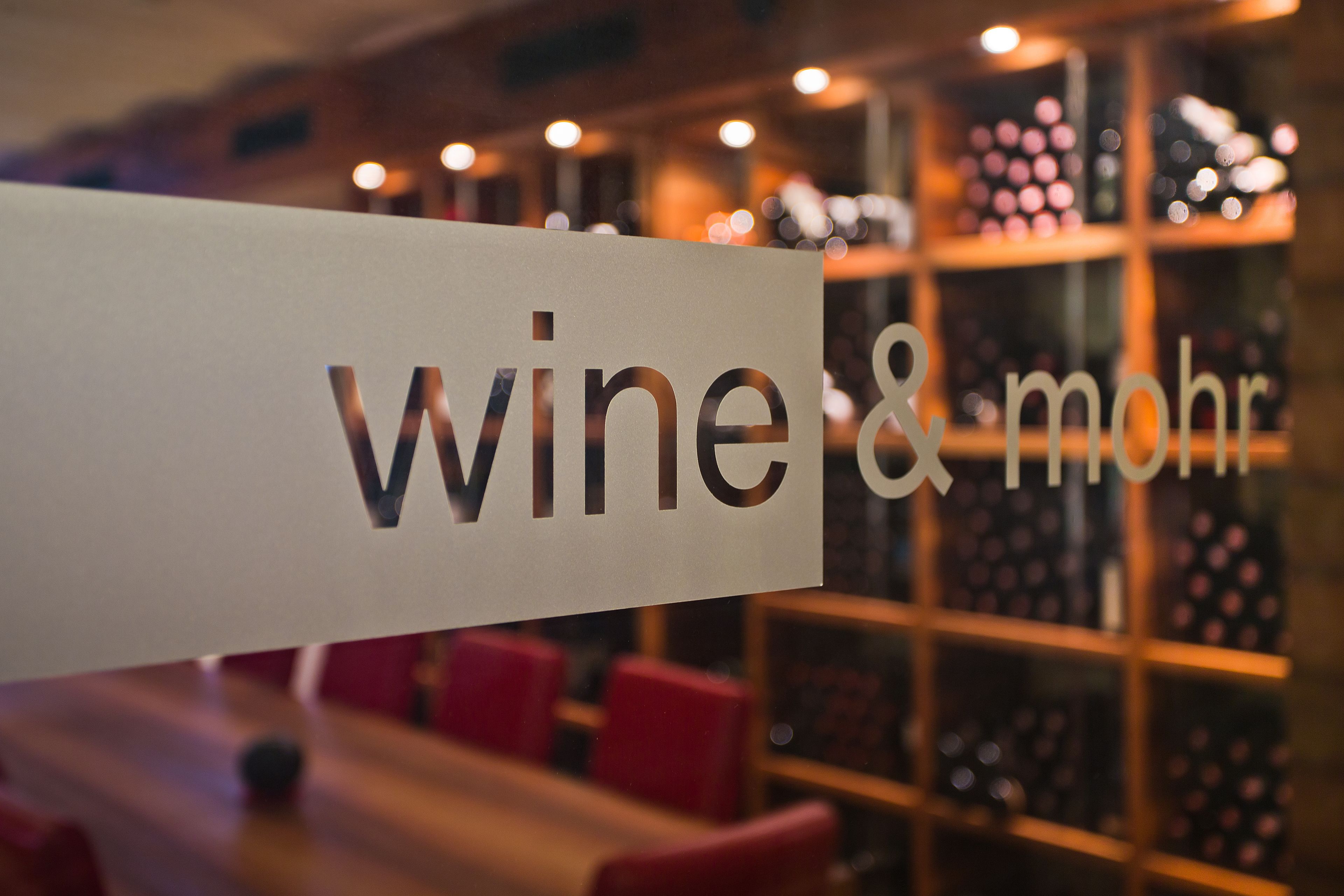 A sign with the text "wine & mohr" in a restaurant setting.