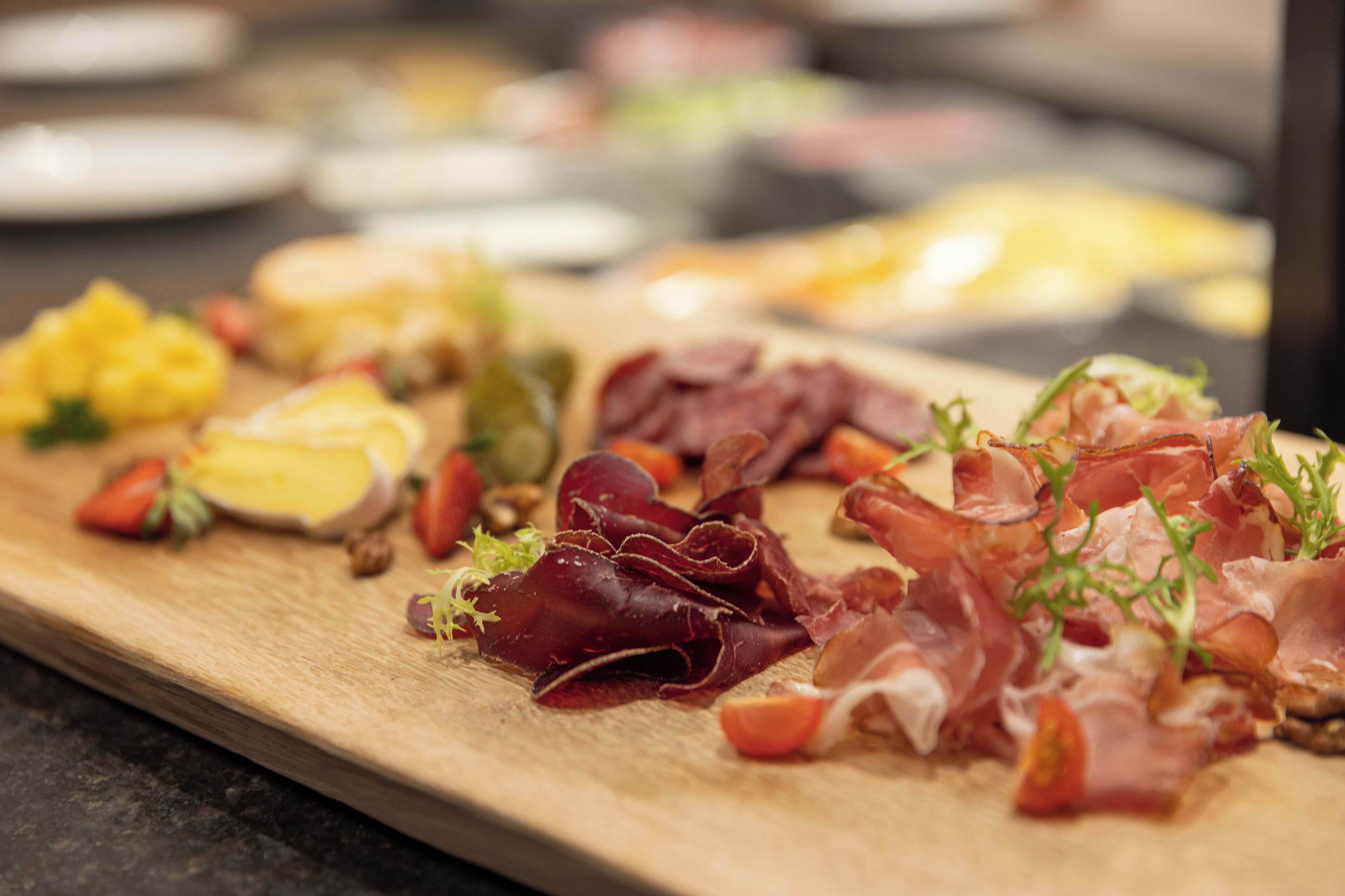Ein Holzboden mit verschiedenen Speisen, darunter Fleisch, Obst und Gemüse.