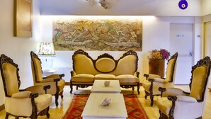 A lobby with a large, ornate ceiling, a central sofa, and matching armchairs. A patterned rug is on the floor, and a painting is on the wall. - Han Hotel (Istanbul)