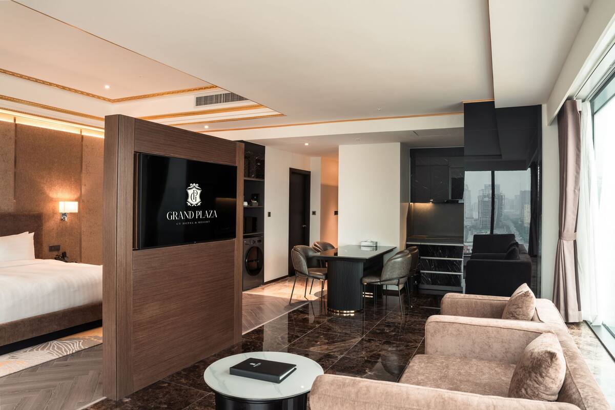 Een moderne hotelkamer met een bed, een televisie, een zithoek en een bank.
