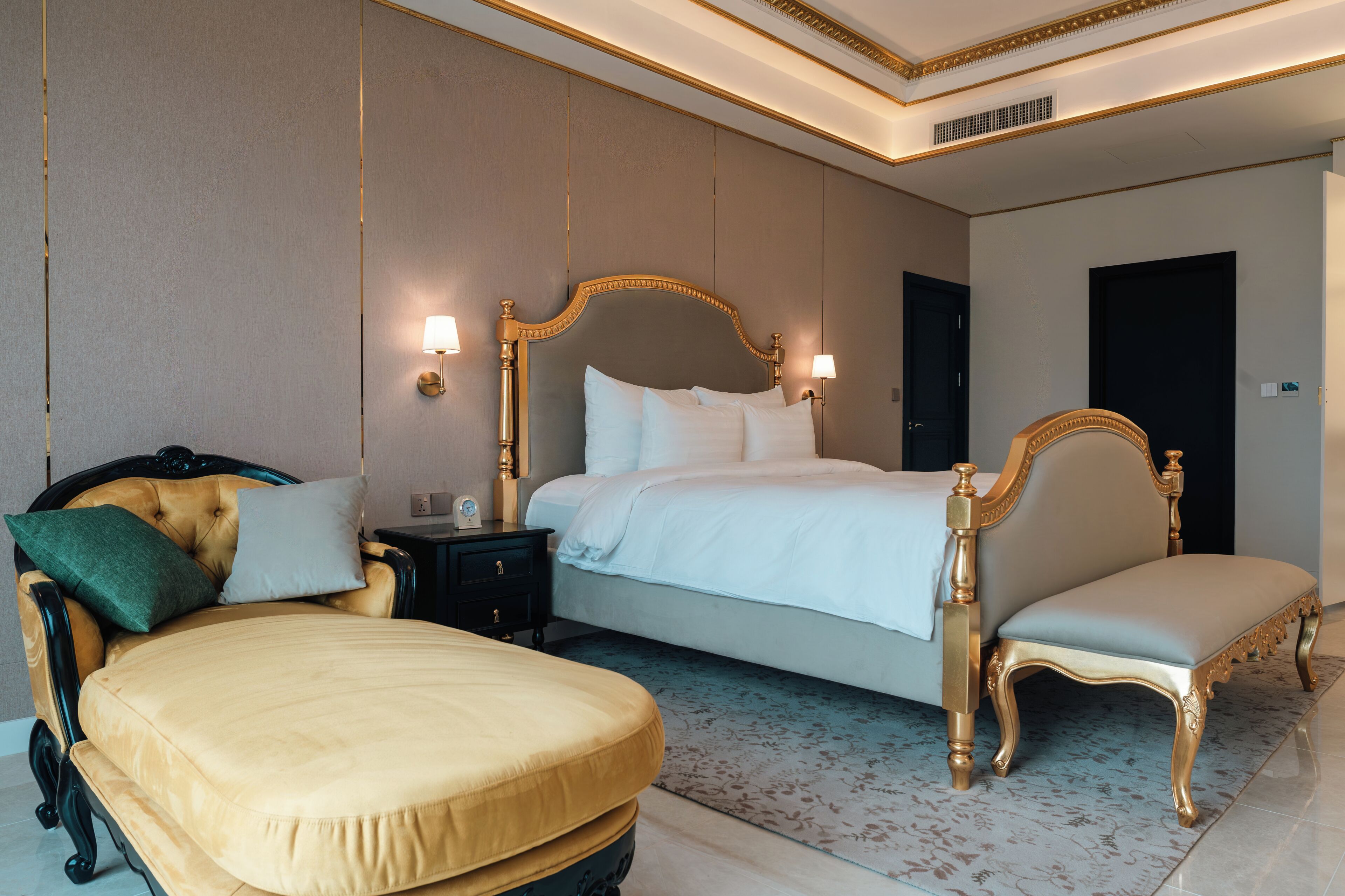 Une chambre d’hôtel avec un grand lit, une table de chevet, une chaise et un canapé.