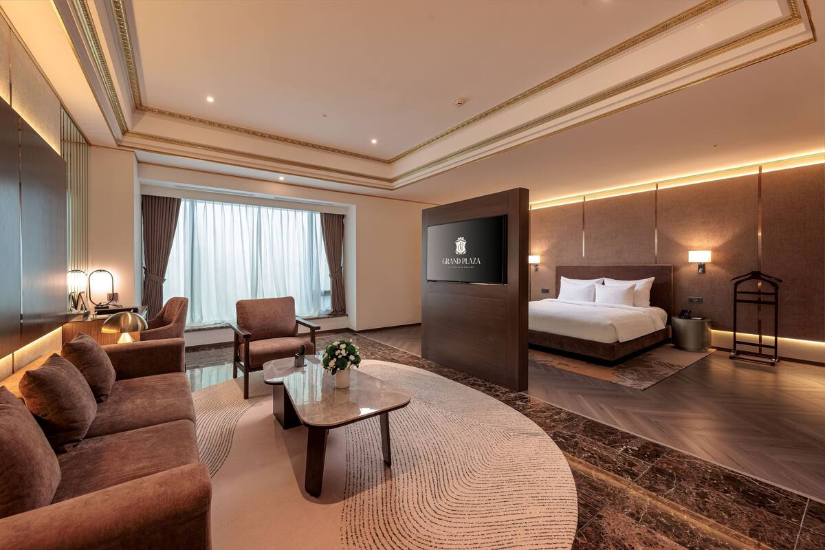 Een moderne hotelkamer met een groot bed, een bank, een salontafel en een televisie.