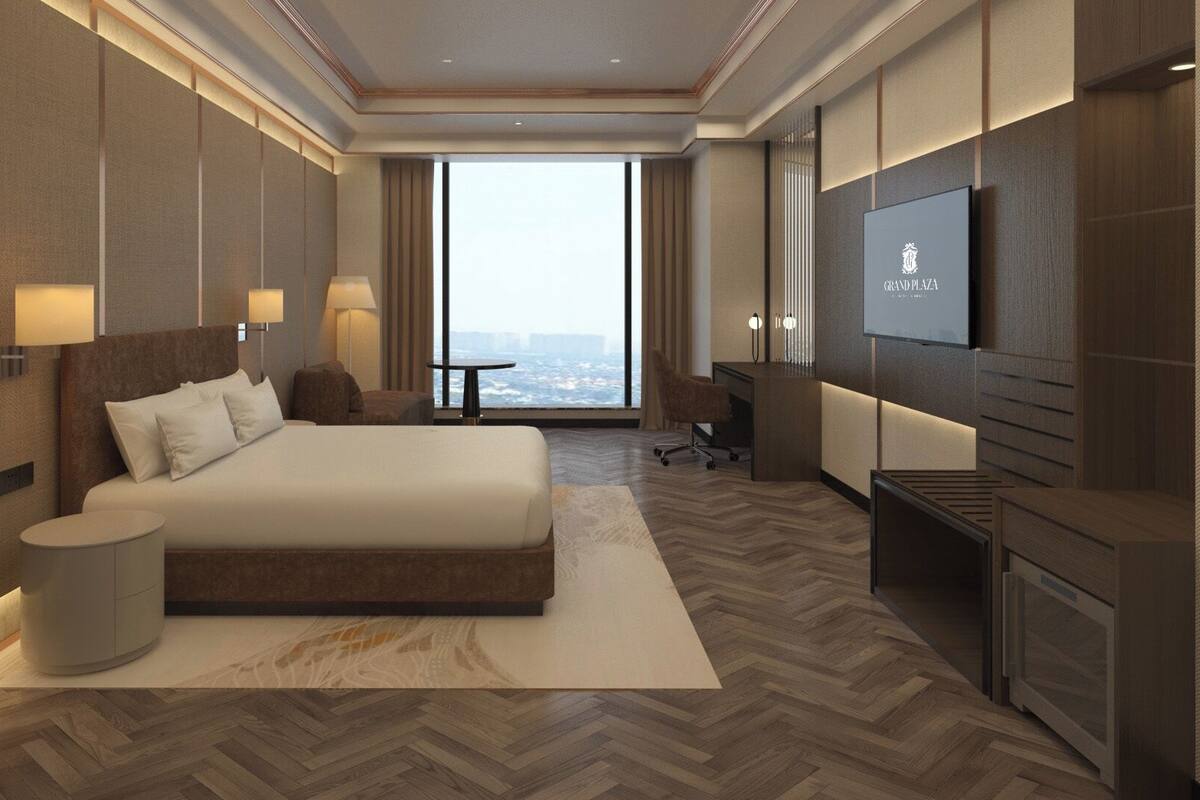 Een moderne hotelkamer met een groot bed, een bureau, een televisie en uitzicht op de stad.
