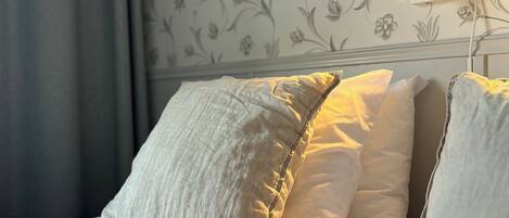 A neatly made bed with pillows and a book on it.