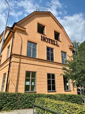 A hotel with a classic architectural style, featuring a prominent "HOTEL" sign on the facade.