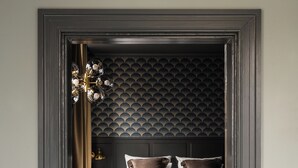 Una habitación de hotel con una cama, una mesa de madera y una silla.