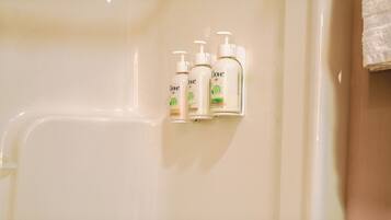 Trois produits de soins personnels de la marque Dove sont fixés sur un mur dans une salle de bain.