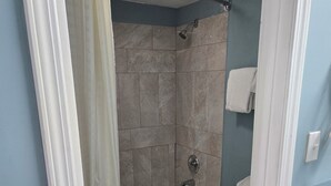 A bathroom with a bathtub, shower, and toilet. - Plaza Inn Springfield (Springfield)