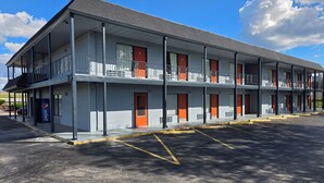 A motel with a two-story structure, multiple rooms, and a parking lot. - Plaza Inn Springfield (Springfield)