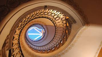 Eine Wendeltreppe mit aufwendiger Metallgalerie und einer Zierdecke.