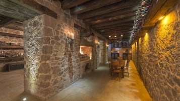 Cozy corridor leads to a dining area with a table and chairs, surrounded by wine bottles.