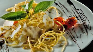 A plate of spaghetti with tomato and basil garnish.