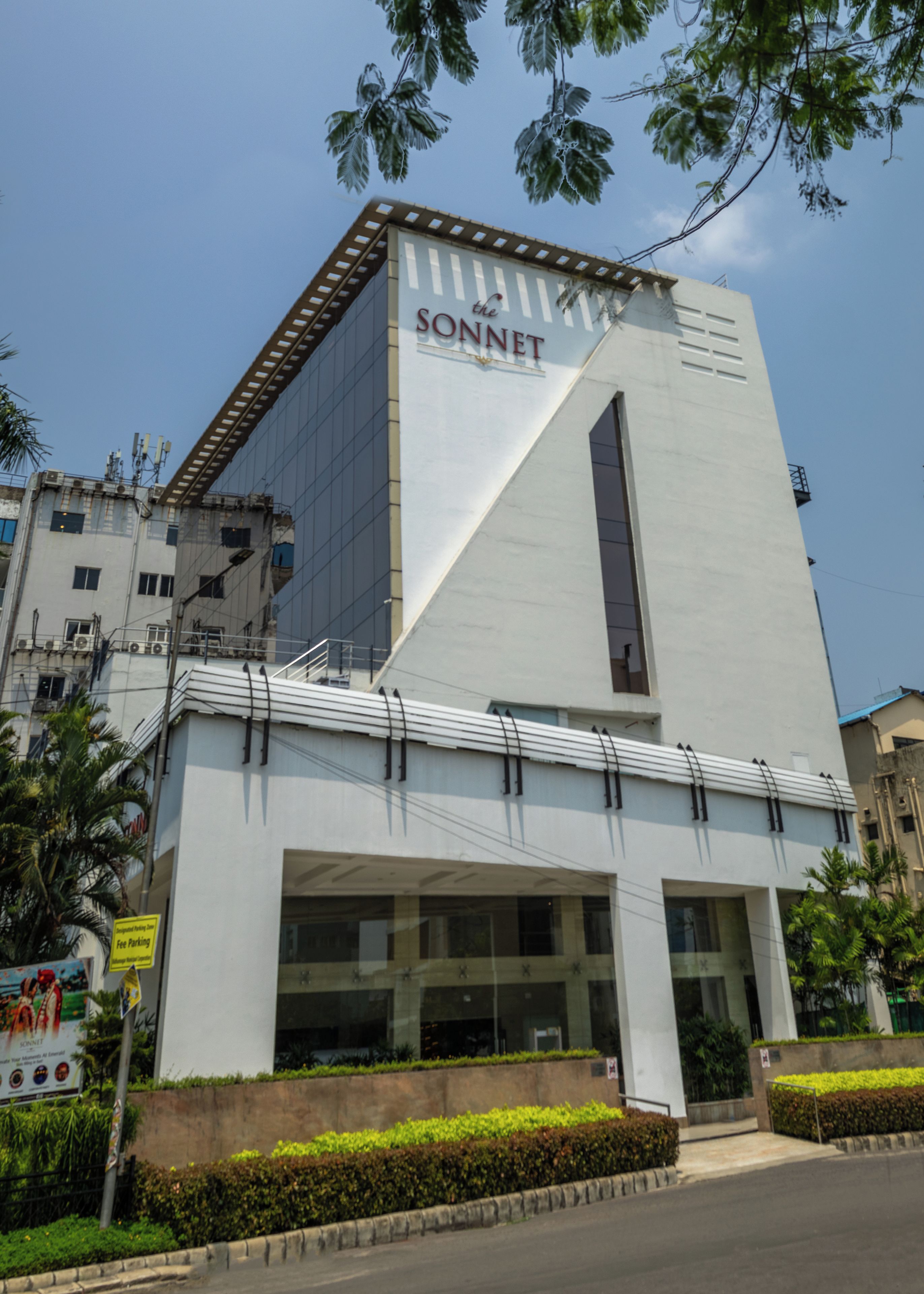 Un bâtiment moderne avec une grande enseigne « SONNET » bien visible sur la façade, de grandes fenêtres et un toit plat.