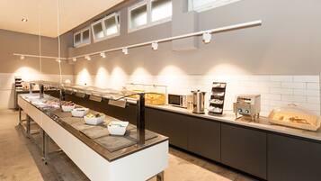 A buffet setup with various food stations and a long serving counter.