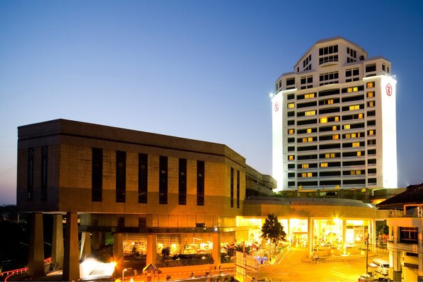 A multi-story hotel with a prominent entrance and a large parking area. - Thumrin Thana Hotel (Trang)