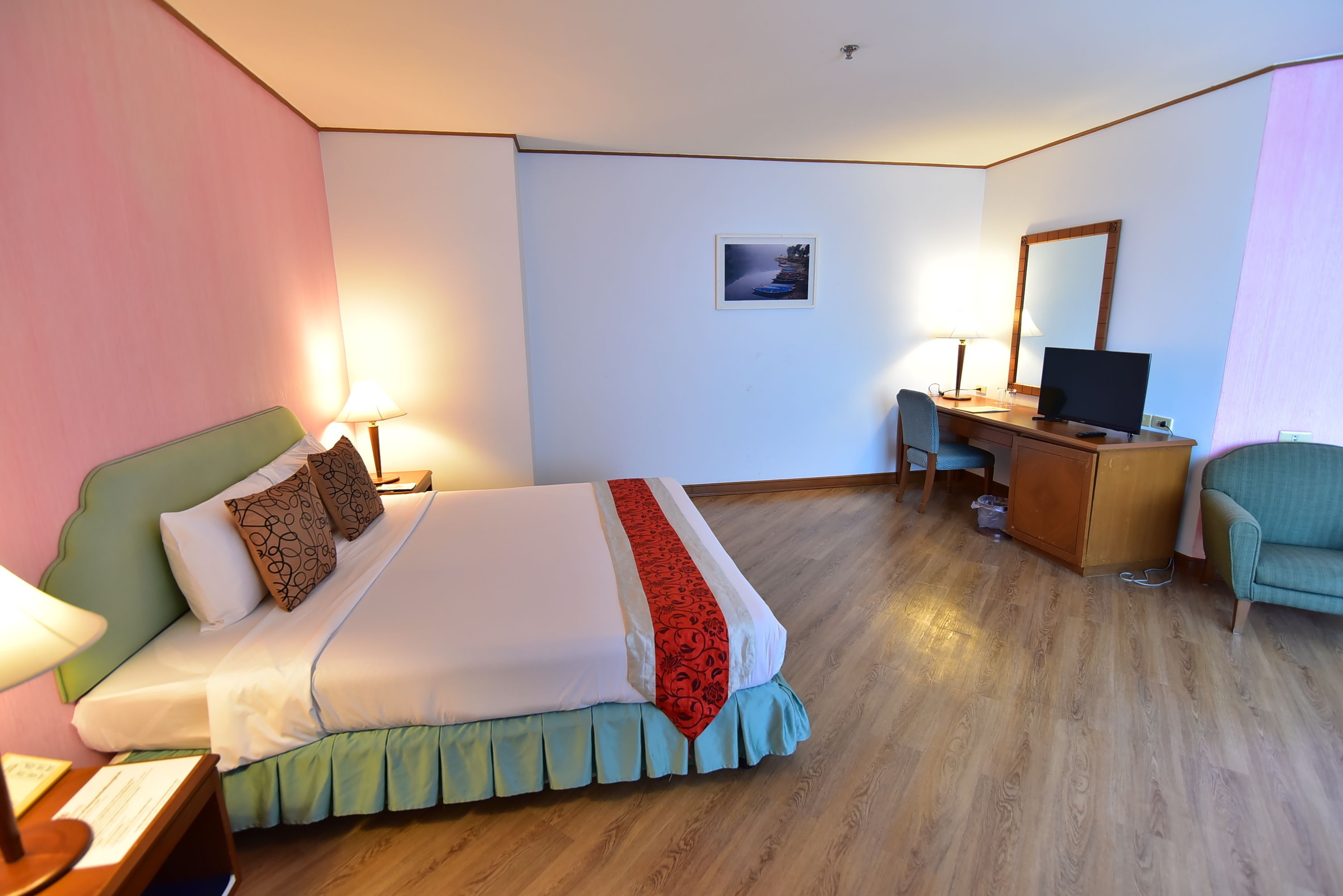 Una habitación de hotel con cama, escritorio, silla y televisor.