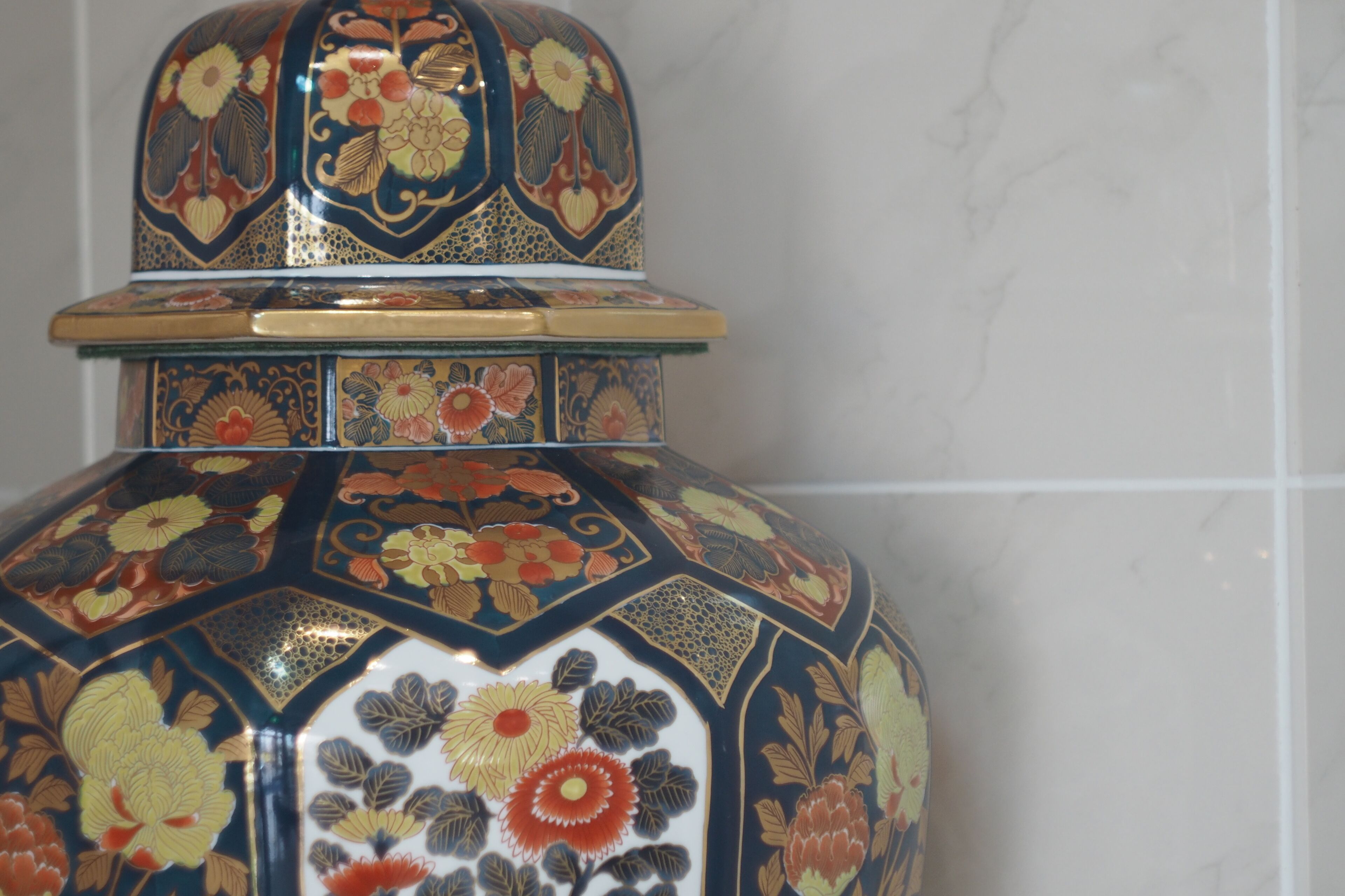 A decorative ceramic container with intricate floral patterns and a lid.