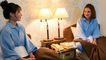 A hotel room with a bed, bedside lamps, a bedside telephone, and a nightstand.