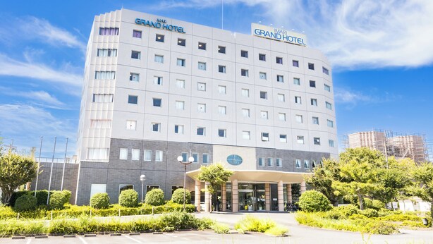 A multi-story hotel with a modern design, featuring a prominent entrance and a landscaped garden area in front. - Imari Grand Hotel (Imari)