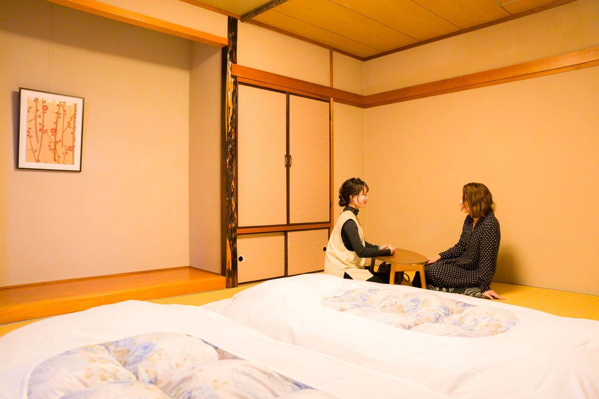 Una habitación con una cama, un armario de madera y un cuadro en la pared.