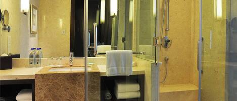 A modern bathroom with a glass-enclosed shower, a marble sink, and a large mirror.
