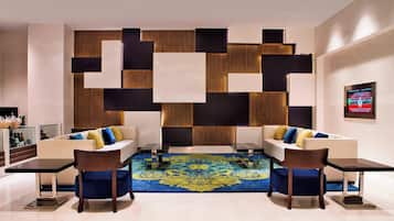 Relax in style with plush sofas and a geometric-patterned wall, surrounded by a stylish seating area.