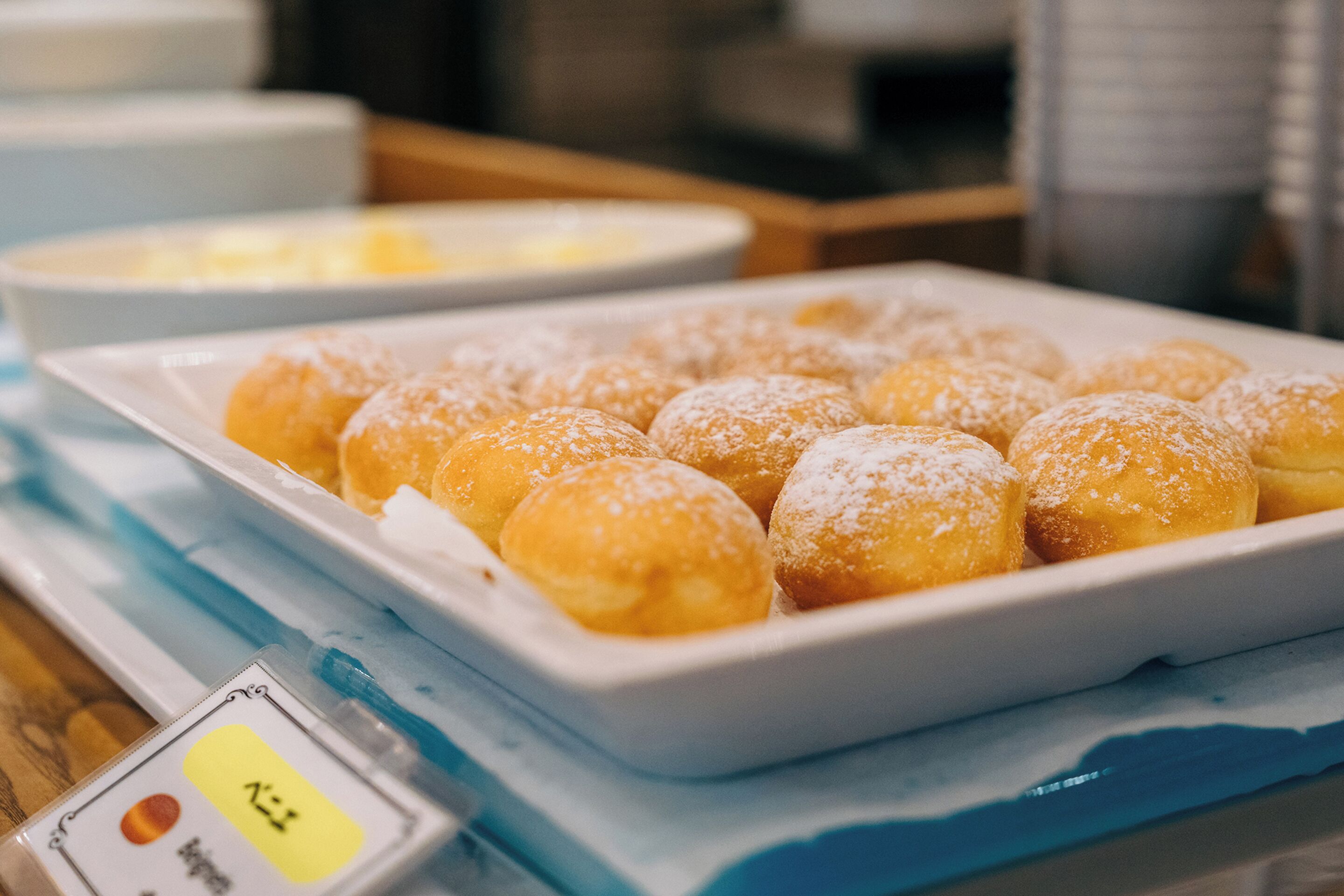 Una bandeja de rosquillas cubiertas de azúcar sobre una mesa.