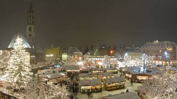 Ett snötäckt torg med ett framträdande kyrktorn och flera marknadsstånd.