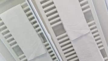 A close-up of a white, textured wall with horizontal slats and a vertical panel.