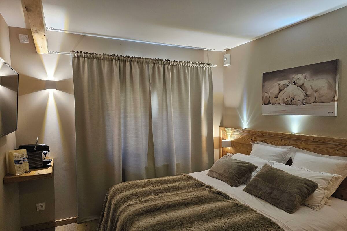 Une chambre d’hôtel avec un grand lit, une tête de lit en bois, une table de chevet avec une lampe et un tableau au mur.
