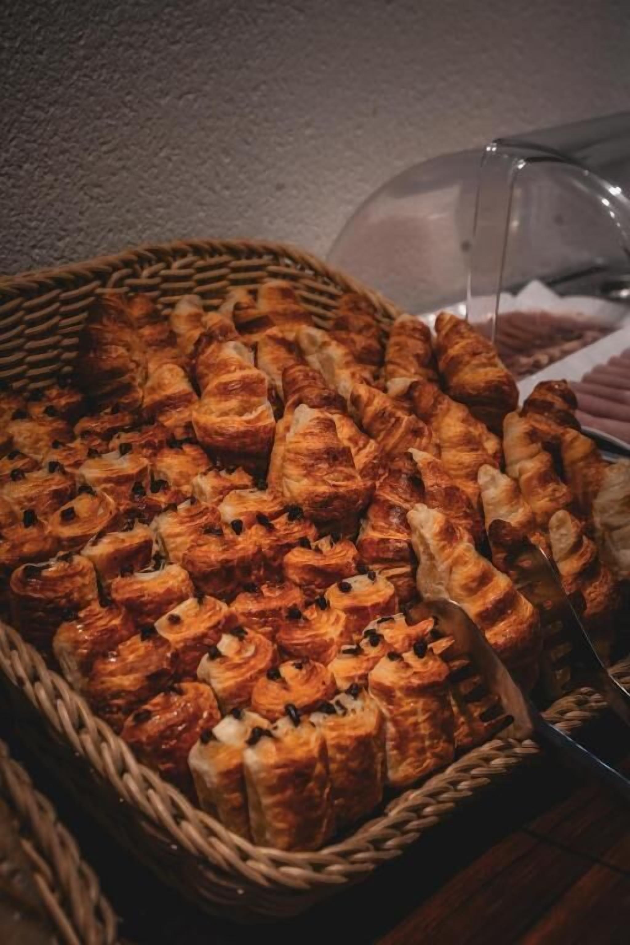 A basket filled with assorted pastries, likely for a buffet or catering service.