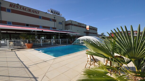 A hotel with a swimming pool, outdoor seating, and a restaurant named 'ALEXIA'. - Brit Hotel Confort Alexia La Souterraine (La Souterraine)