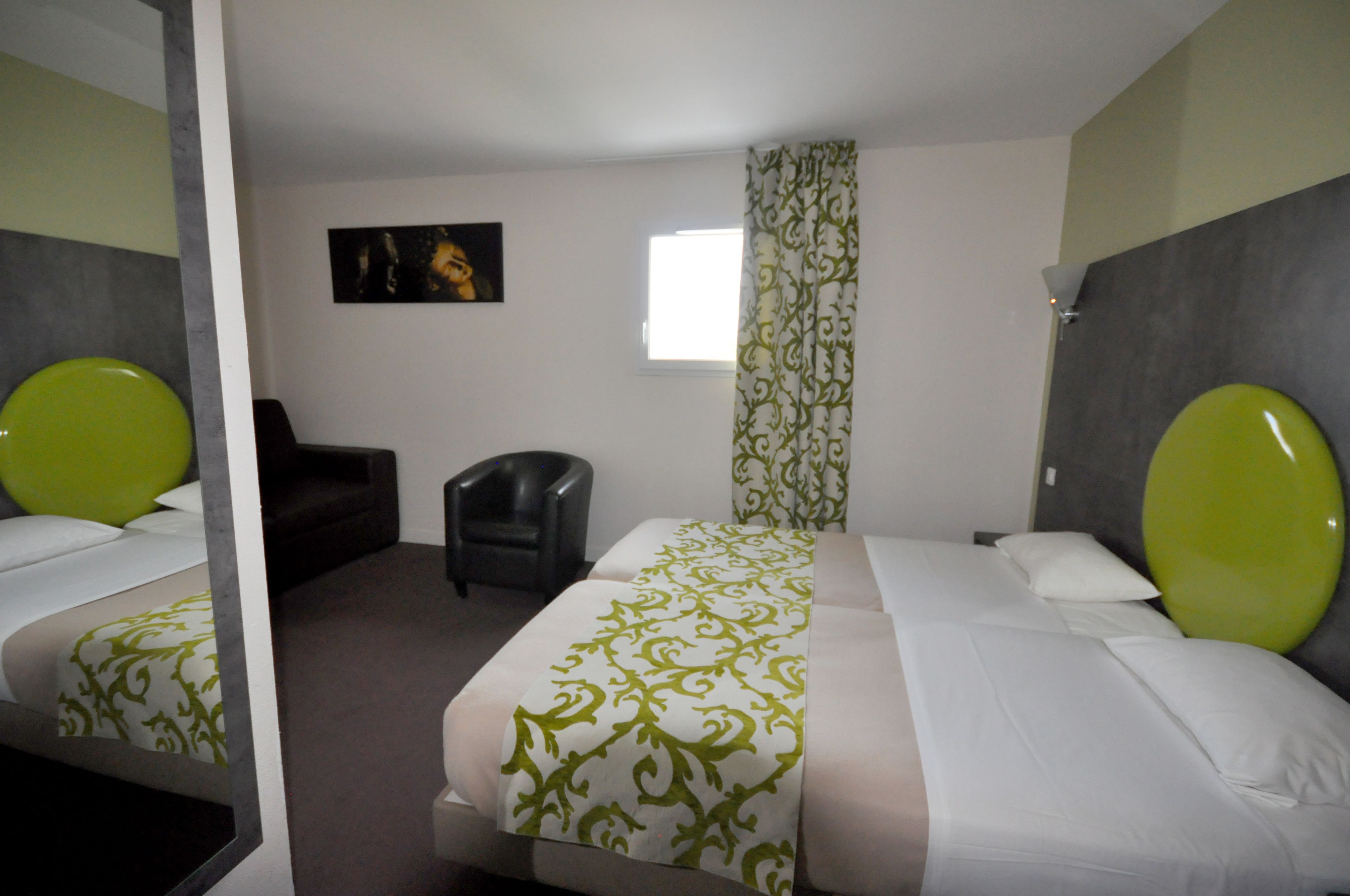 A hotel room with two beds, a chair, a window, and a painting on the wall.