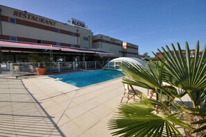 A swimming pool area with a restaurant named 'ALEXIA' in the background. - Brit Hotel Confort Alexia La Souterraine (La Souterraine)