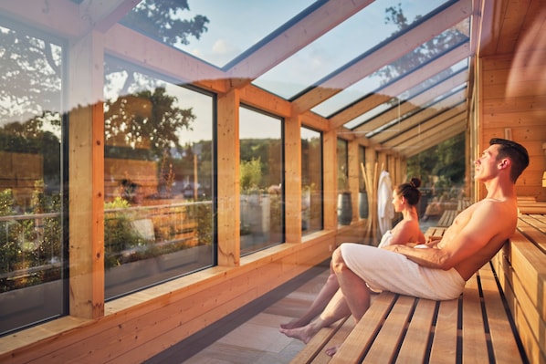 A wooden deck with large windows overlooking a garden.