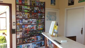 A reception desk with a wall of travel brochures and a map. - Ace Motor Lodge (Rotorua)
