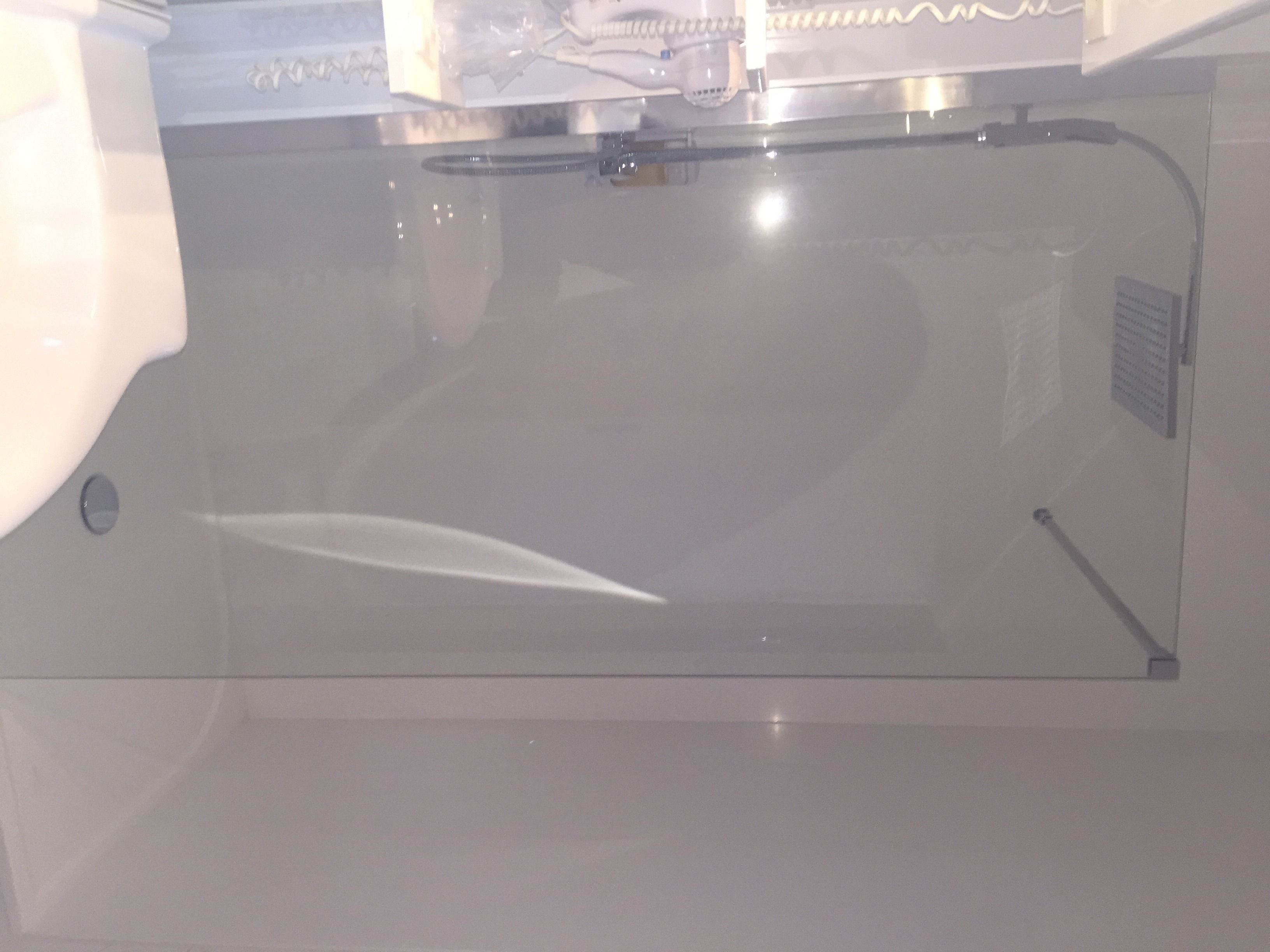 Une cuisine équipée d’un évier en acier inoxydable, d’un robinet et d’une hotte aspirante.