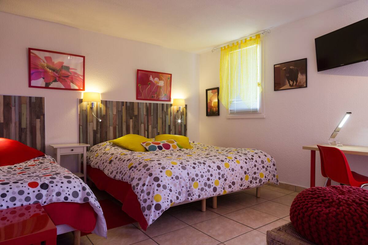 A bedroom with two beds, a desk, and a chair.