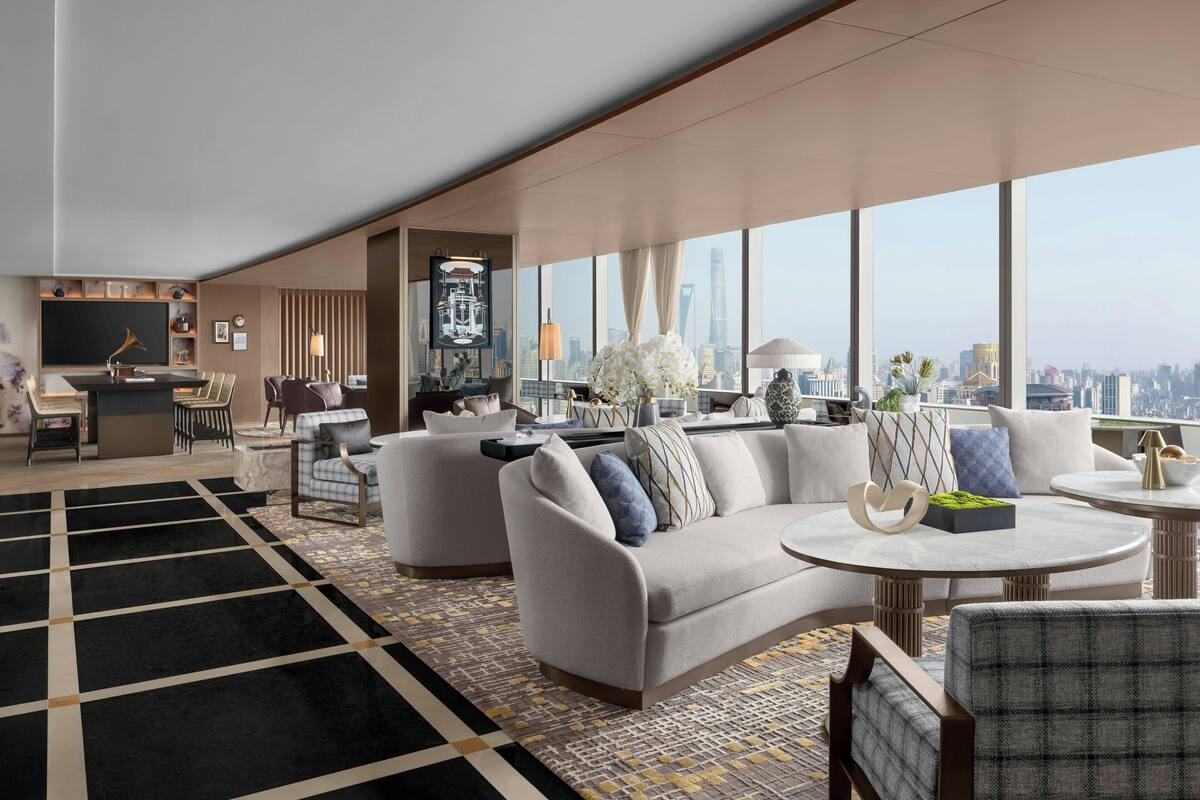 Un moderno vestíbulo de hotel con un amplio espacio de estar, un bar y un ventanal con vistas a la ciudad.