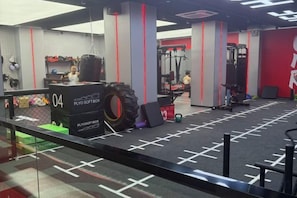 A gym with exercise equipment, a punching bag, and a weight bench. - Gladden Hotel (Fenggang Town) (Dongguan)