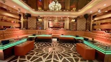 A luxurious lounge area with plush seating, a patterned floor, and ambient lighting.