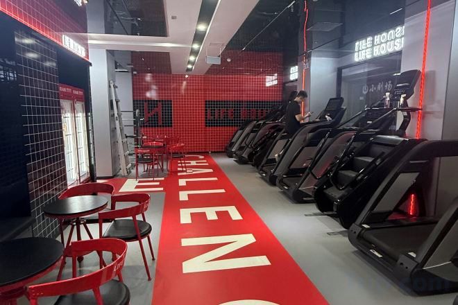 A gym with treadmills, red chairs, and a red carpet with 'CHALLENGE' written on it.