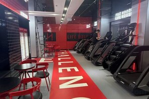 A gym with treadmills, red chairs, and a red carpet with 'CHALLENGE' written on it. - Gladden Hotel (Fenggang Town) (Dongguan)