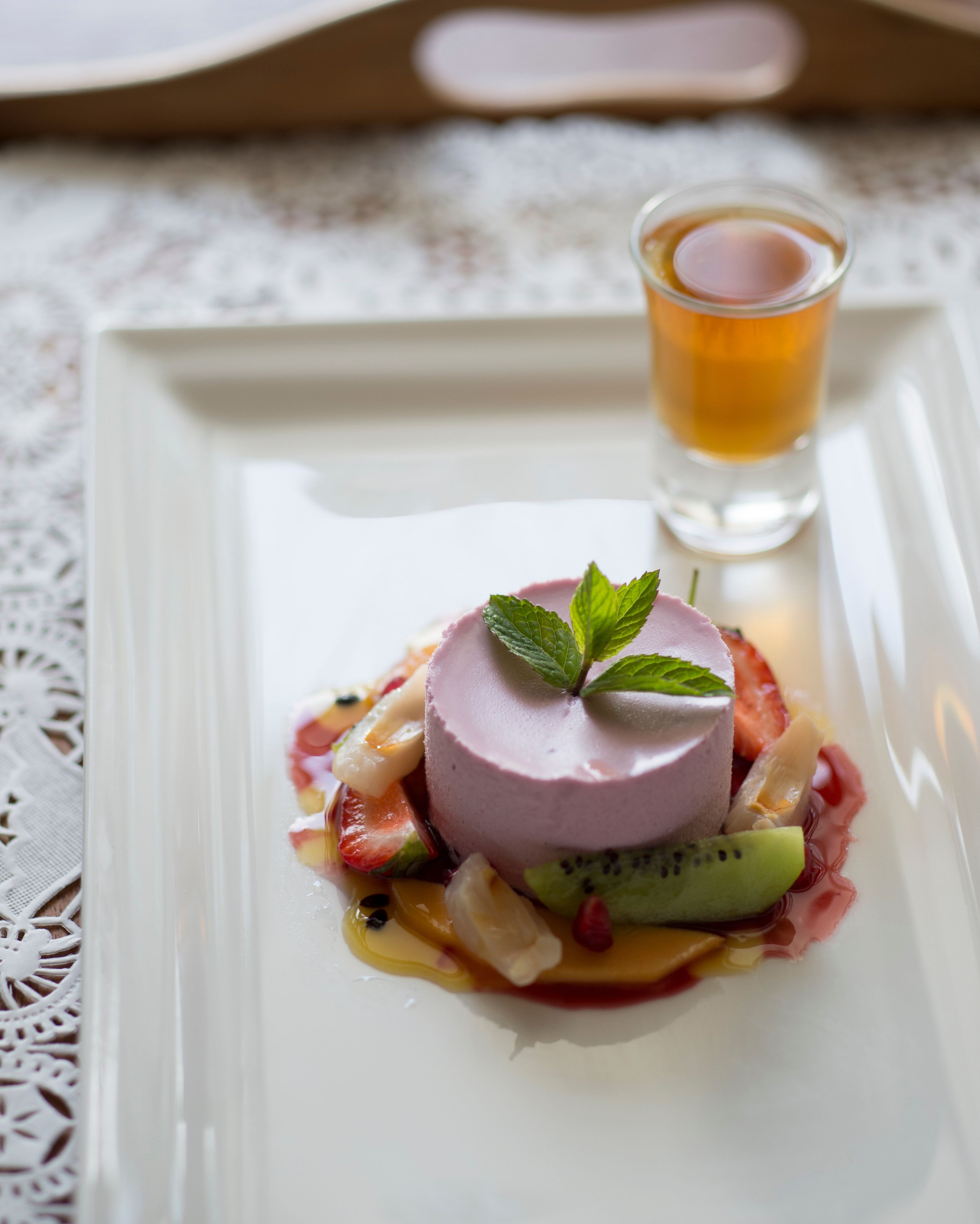 A dessert on a white plate with a glass of tea beside it.