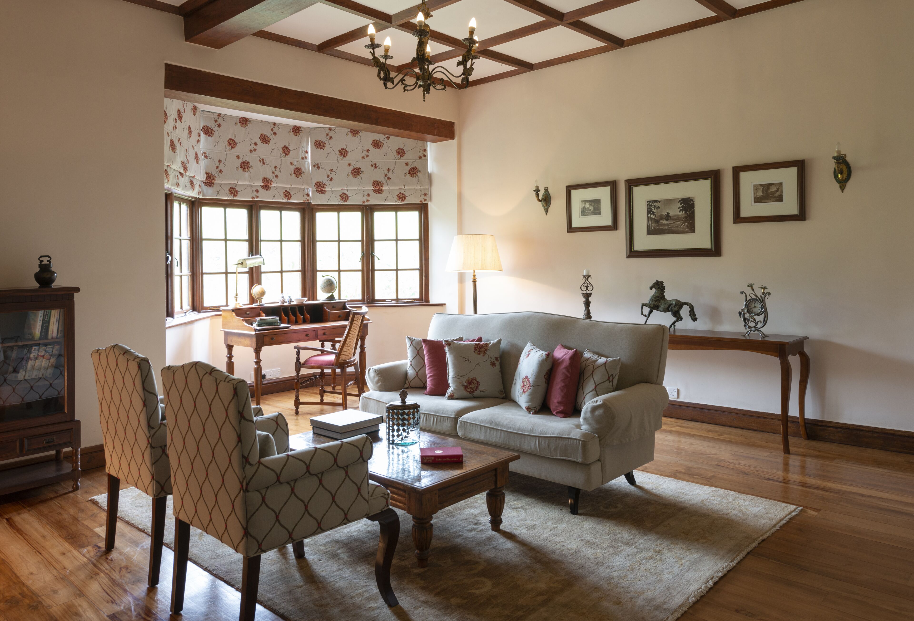 A living room with a sofa, chairs, a coffee table, and a chandelier.