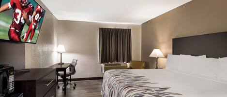 A hotel room with a bed, a desk, a chair, a television, and a window with curtains.