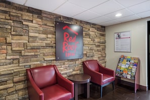 A Red Roof Inn sign, two leather chairs, a small table, and a bulletin board with various notices. - Red Roof Inn Allentown South (Allentown)