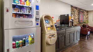 A vending machine with snacks and drinks, a coffee machine, and a counter with a coffee maker.