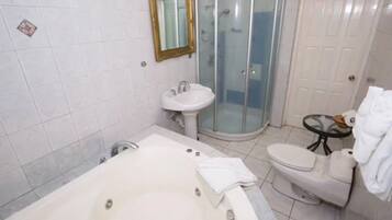 A bathroom with a bathtub, a sink, a toilet, and a glass shower enclosure.